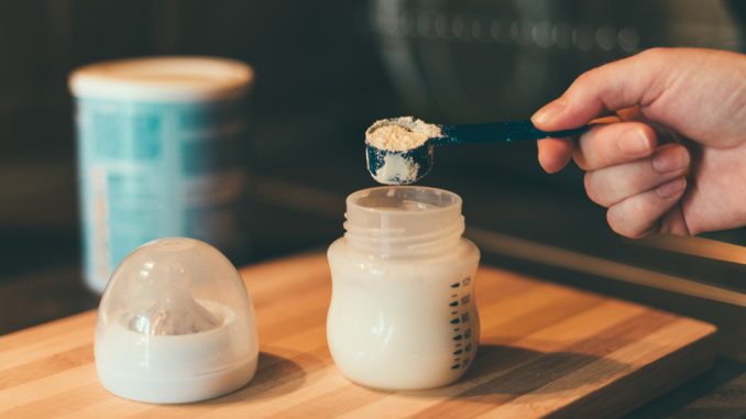 Mother,Making,Baby,Formula,In,Milk,Bottle,For,A,Newborn